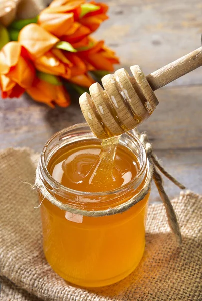 Miele nel vasetto e fiori — Stockfoto