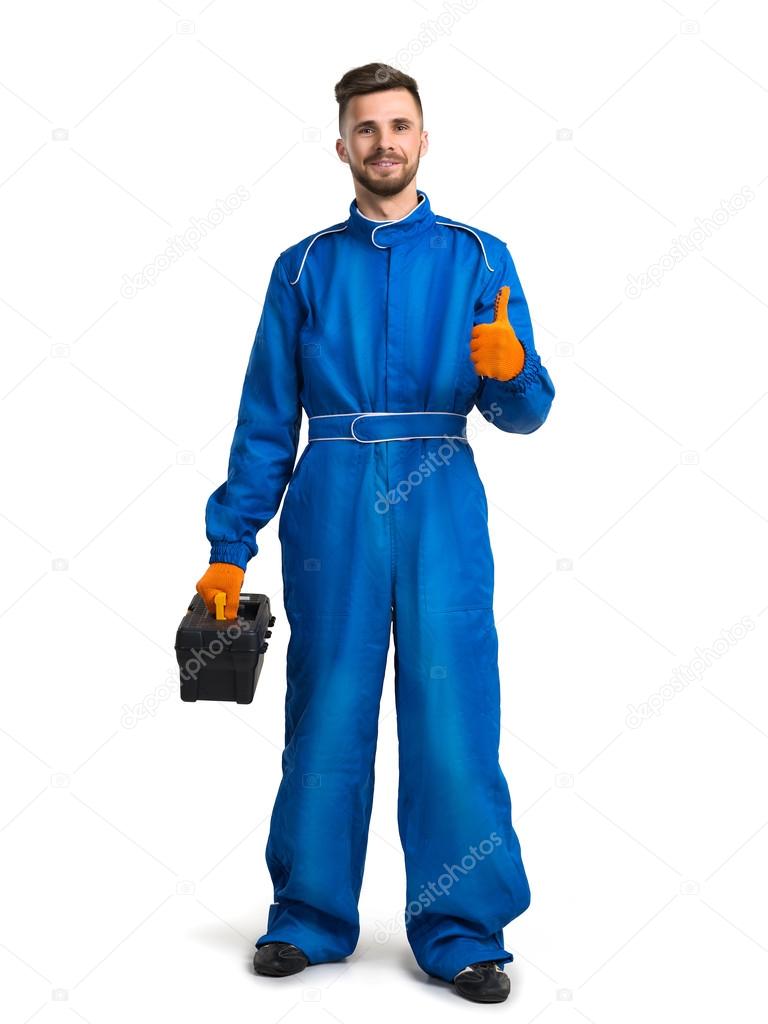 Smiling young mechanic in boiler suit giving thumb up against