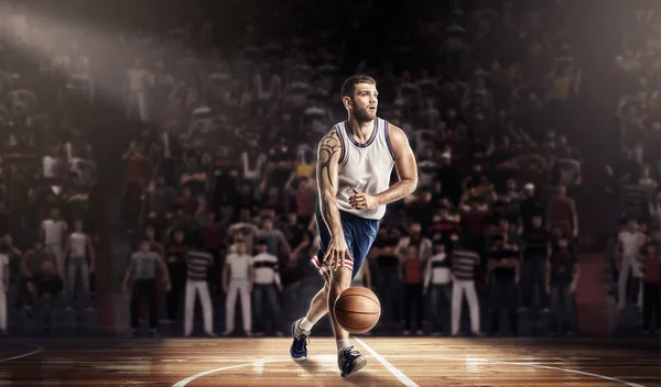 Баскетболист в свете на профессиональной площадке с мячом — стоковое фото