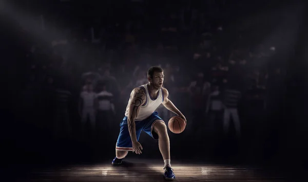 Basketball player on durk professional court with ball — Stock Photo, Image