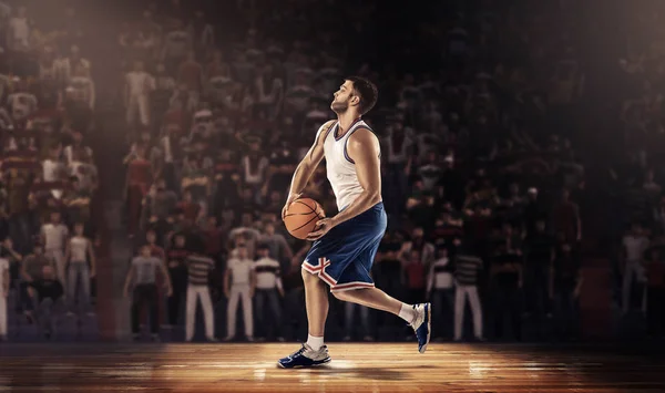 Basketballer springt mit Ball auf Stadion — Stockfoto