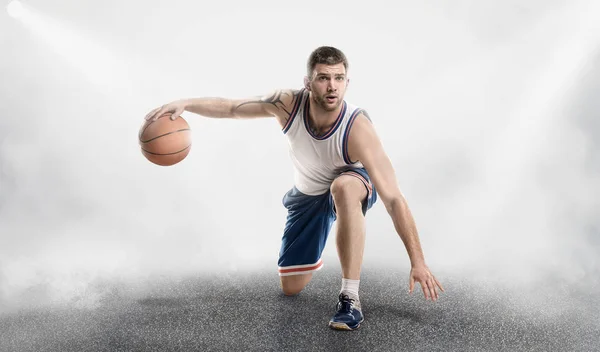 Basketbalspeler in de mist op de grond met bal — Stockfoto