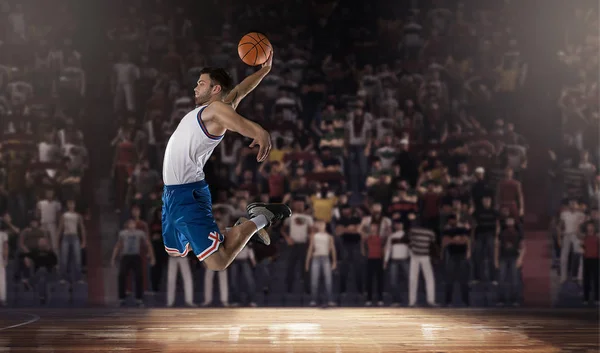 Jugador de baloncesto saltando con pelota en el estadio — Foto de Stock