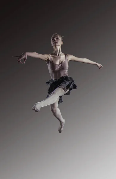 Mladá blondýnka krásná baletka je skákání na světlé pozadí — Stock fotografie