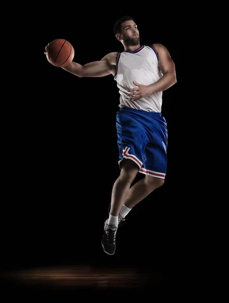 Jogador de basquete profissional isolado em preto com bola e perquet — Fotografia de Stock