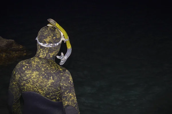Gece Diver denize yakın kayaların üzerinde