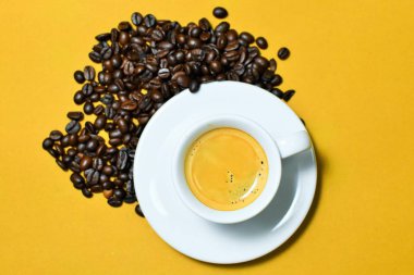 Kahverengi zemin üzerine kahve çekirdekleri ile sıcak espresso fincan.