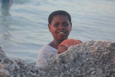 tropikal Adası Zanzibar kumsalda bebeği ile yerel kadın
