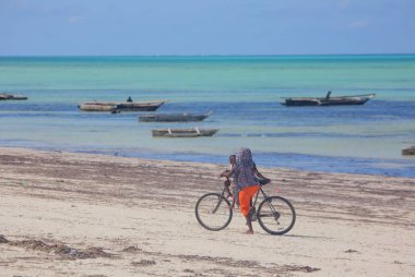 Aile Zanzibar sahilde bisiklet sürme 