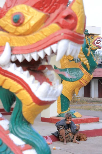 Arme Frau in der Nähe von Drachen in Laos — Stockfoto