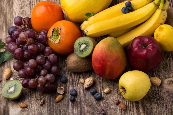 Verschiedene Früchte auf hölzernem Boden — Stockfoto