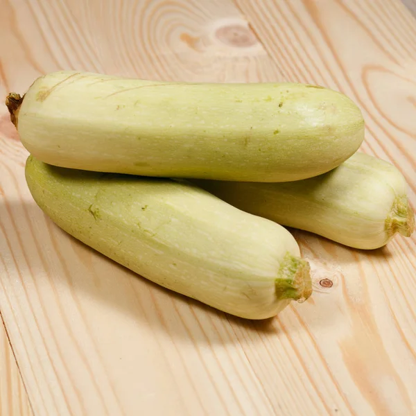 Some fresh green zucchini on a light  wooden background — Stock Photo, Image