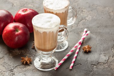 Sıcak bir içecek sütlü köpük, elma, baharatlar, saman