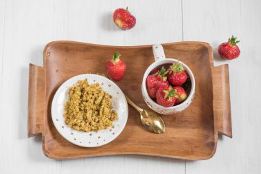 Kahvaltı bir tepsi, buğday lapası ve olgun kırmızı çilek 