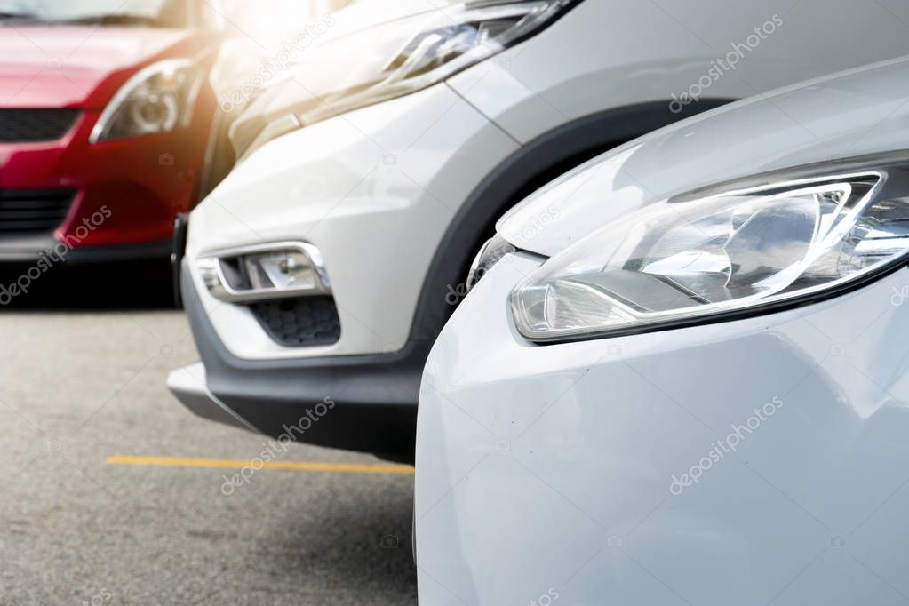 Front of cars parking on the road. With a yellow border line.