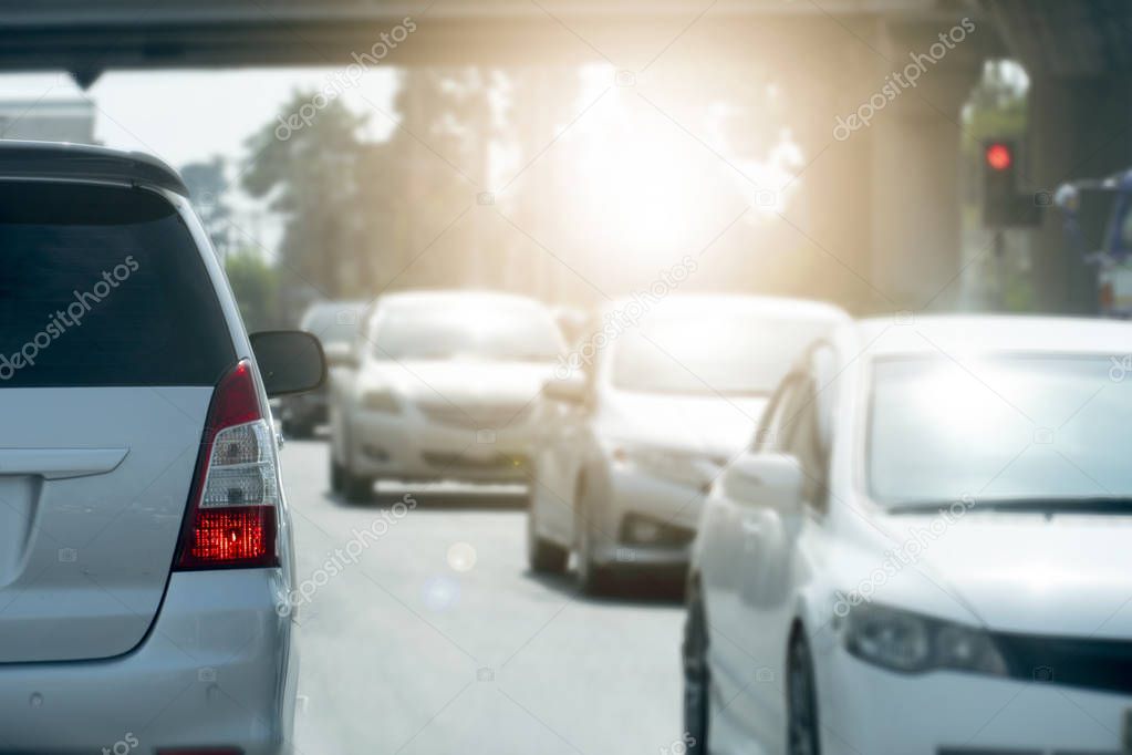 Brake of white car on asphalt roads during rush hours for travel or business work. Evening environment with orange light. 