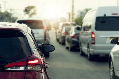 Seyahat ya da iş için yoğun saatlerde asfalt yollarda kırmızı araba fren yapıyor. Arabalar arka arkaya park edilmiş..