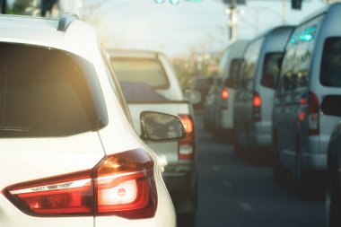Asfalt yolda beyaz araba duraklama lüksü. Şehir merkezinde çalıştıktan sonra trafik sıkışıklığı..