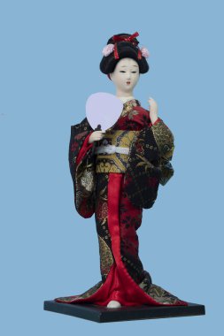 Oryantal Japon Brocade Kimono Kabuki Bebek Geyşa figürü. İzole edilmiş mavi arkaplanda duran ön manzara.