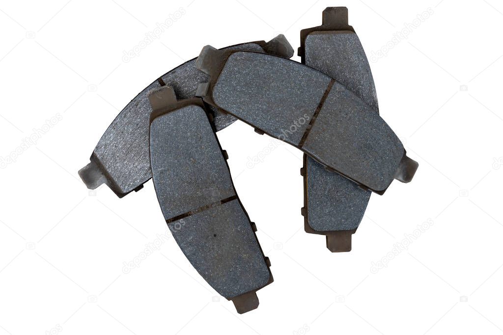 Four used car brake pads that are stacked together on isolated white background. with clipping path.