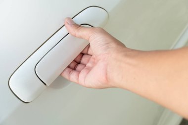 Beyaz arabanın kapısını açan adamın eli..