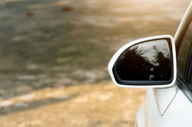 Beton zemine park etmiş beyaz arabanın aynasının yanına yaklaş..