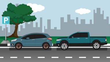 Parkın yanında park edilmiş iki araba var ve arka planda büyük bir şehir manzarası var..