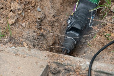 İnşaat işçisi, endüstriyel kullanım için delinen drenaj yolları için beton zemin. Toprağın dış yüzeyi boyunca