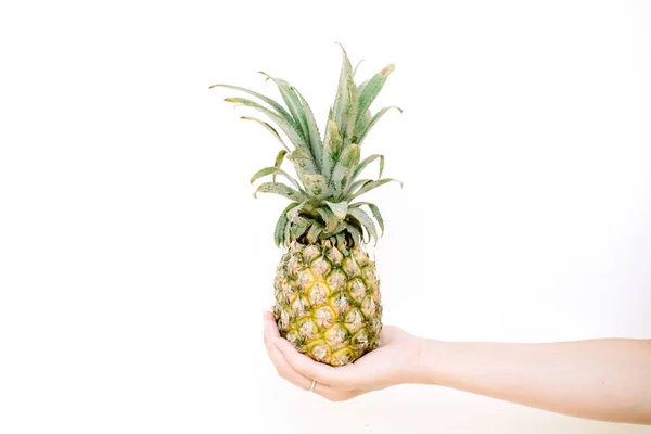 Girl's ręka gospodarstwa ananas — Zdjęcie stockowe