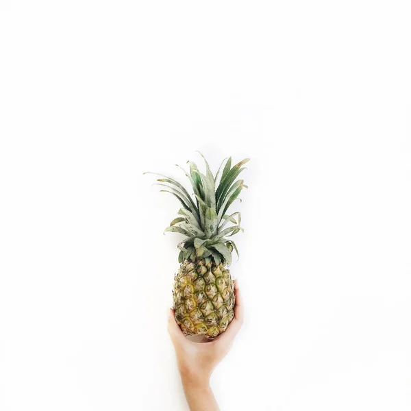 Рука девушки держит ананас — стоковое фото