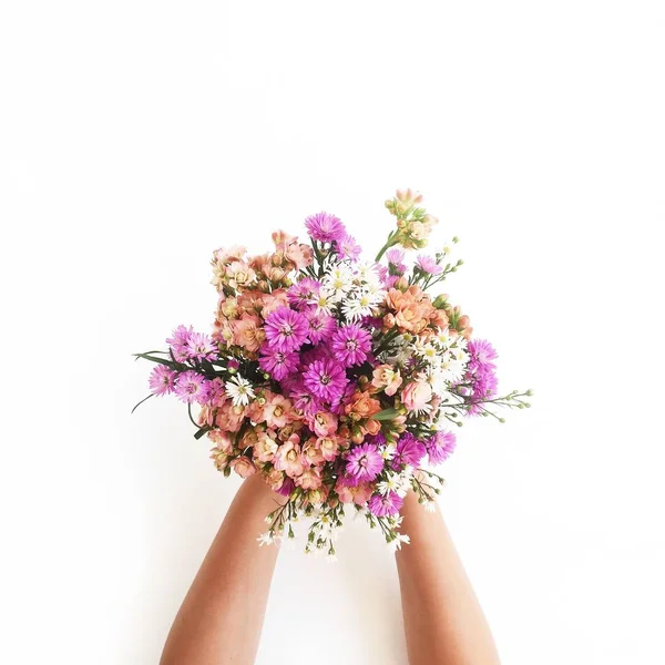 Manos de niña sosteniendo ramo de flores silvestres — Foto de Stock