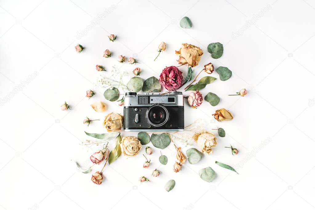vintage retro photo camera, beige roses and green leaves