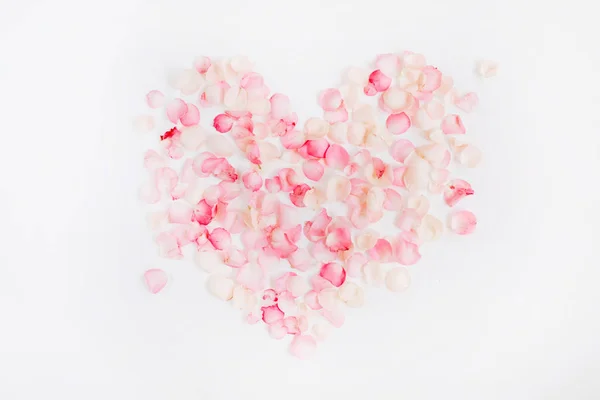 Hjärtsymbolen gjord av rosa rosenblad — Stockfoto