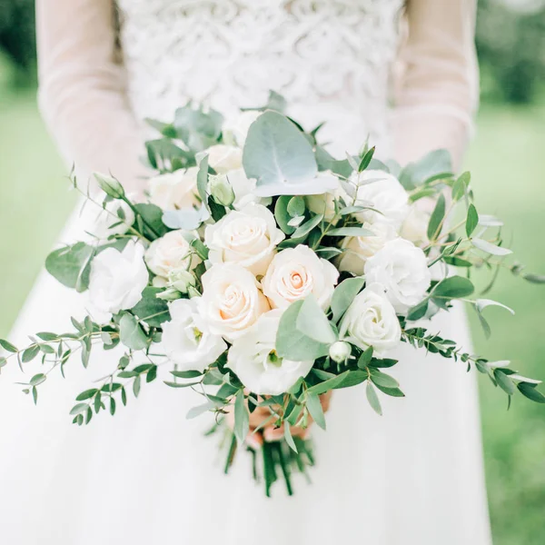 Beautiful wedding bouquet in bride's hands — Stock Photo, Image