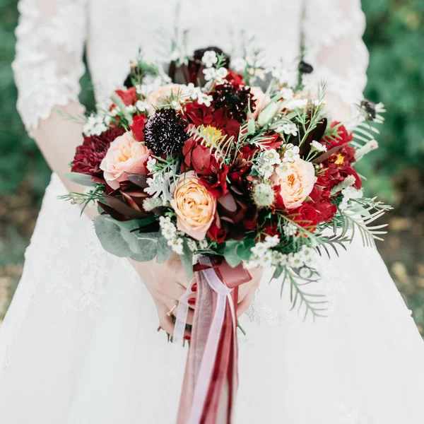 ช่อดอกไม้แต่งงานที่สวยงามในมือของเจ้าสาว — ภาพถ่ายสต็อก