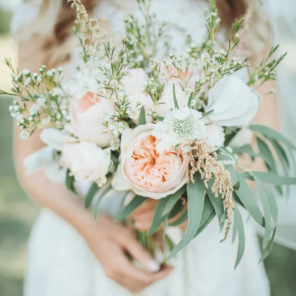Mooie bruiloft boeket in handen van de bruid — Stockfoto