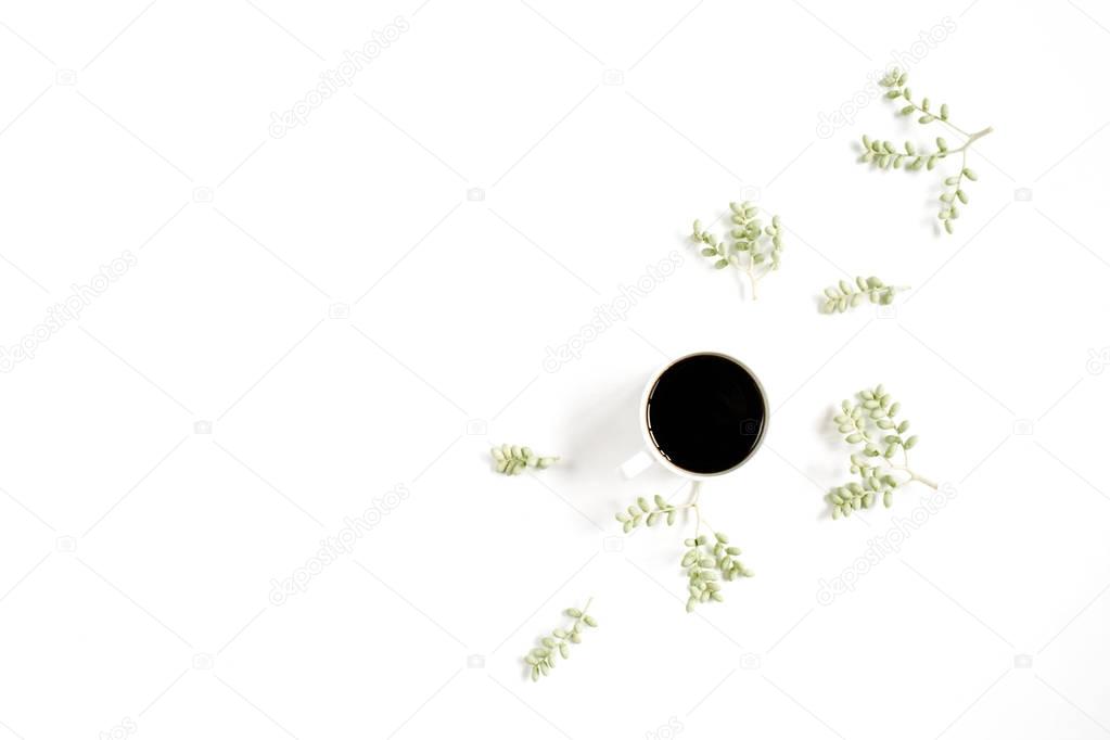 Coffee cup and green branches