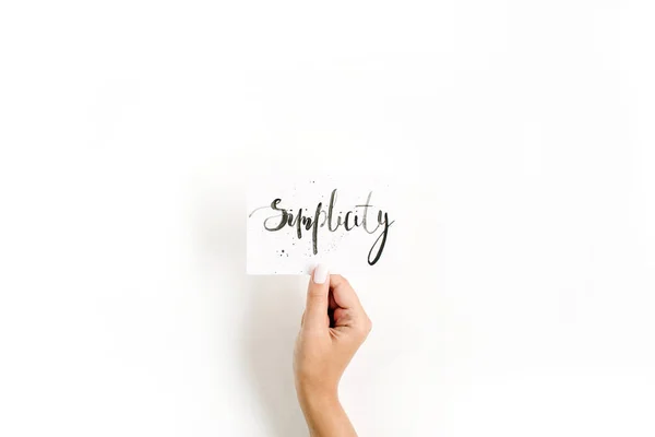 Pigens hånd holder kort med ordet Enkelhed - Stock-foto