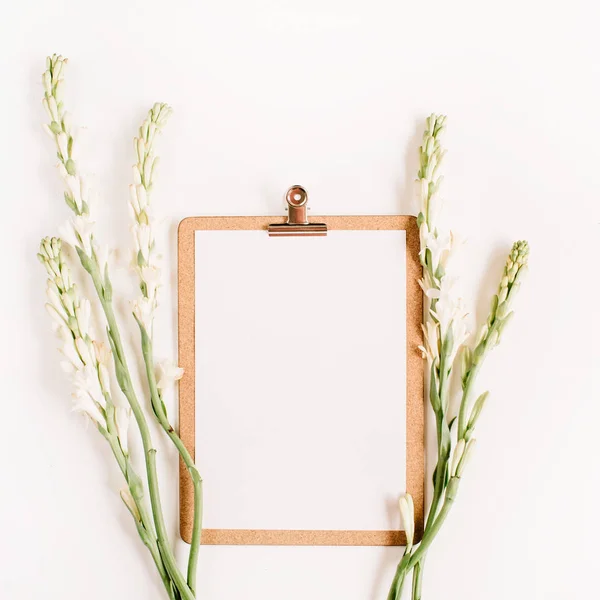 Portapapeles y flores blancas . — Foto de Stock