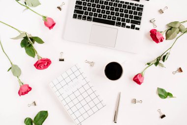 Dizüstü bilgisayar, kırmızı gül çiçekler, kahve fincanı, defter ile çalışma alanı