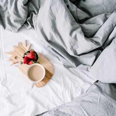 Kahve kupa ve çilek ile yatakta kahvaltı