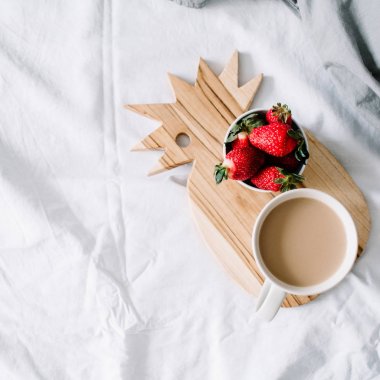 Kahve kupa ve çilek ile yatakta kahvaltı