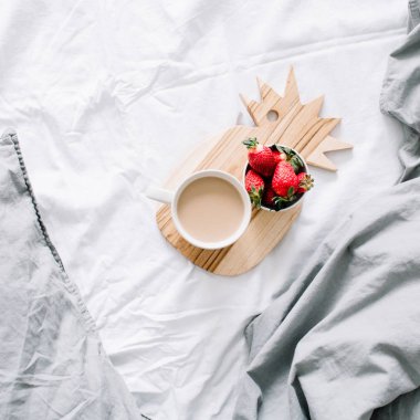 Kahve kupa ve çilek ile yatakta kahvaltı