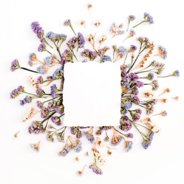Boş beyaz kağıt mavi ve mor kurutulmuş çiçekli çerçeve üzerinde boş 