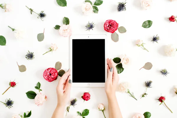 Les mains de fille tenant la tablette sur le cadre floral — Photo