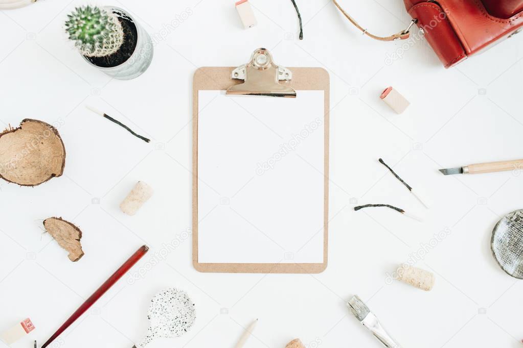 Clipboard with blank paper, retro camera, succulent, tools for handmade arts