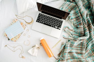 Dizüstü bilgisayar ile yatakta kadınsı ev ofis