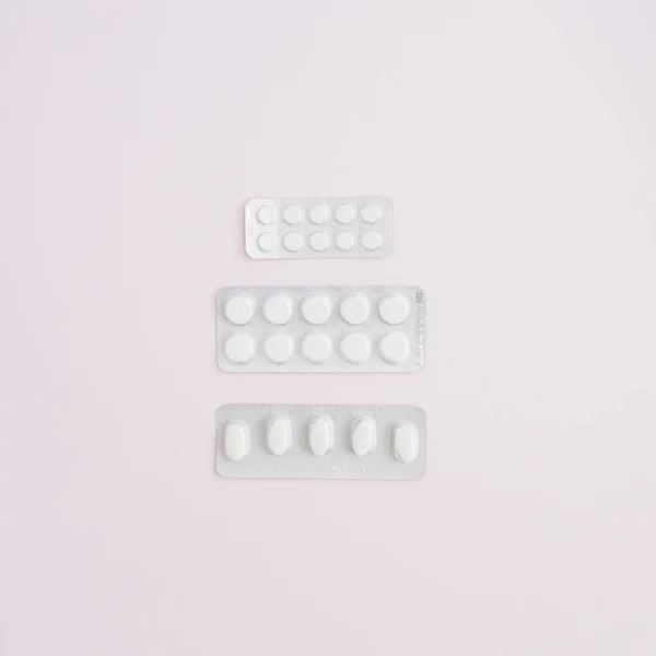 Obat pil pada latar belakang merah muda — Stok Foto