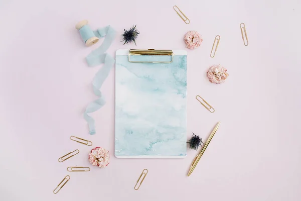 Klembord, rose toppen, blauwe lint, gouden pen en clips — Stockfoto