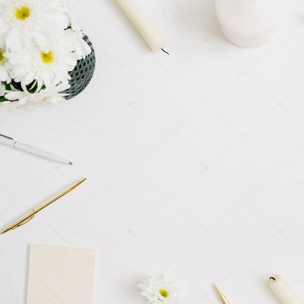 workspace with chamomile flowers bouquet and marble diary